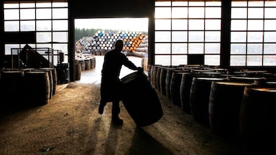 A cooper rolls a whisky cask along the floor before starting the process to repair it, using traditional methods and tools, at the Speyside Cooperage in Craigellachie in Speyside, Scotland. File photo/Reuters 
