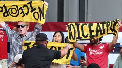 Protesters hold up signs against ICE before being ejected from Trump’s campaign rally in Dalton, Georgia on Friday. Reuters