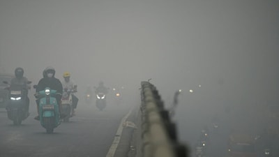 Motorists wearing protective masks ride on a bridge as haze from wildfires shrouds the area in Palembang, South Sumatra province, Indonesia, October 15, 2026. Reuters