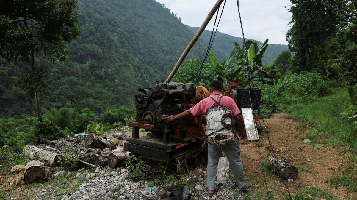 A man walks past a drilling machine damaged by protesters opposing the proposed 11,500 MW Siang Upper Multipurpose Dam Project. Reuters