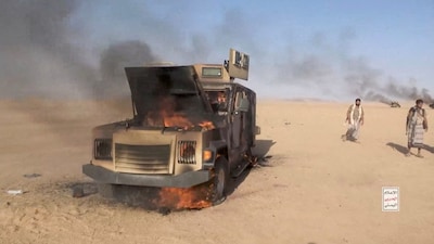 Iran-aligned Houthi fighters move next to a destroyed vehicle following what the source described as an attack on Saudi-backed forces in the location given by the source as al Jawf governorate, Yemen. File- Reuters