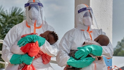 Congolese medical workers dressed in personal protective equipment carry children tested and cleared off from Ebola from Saint Nicholas orphanage, at the Centre Medical Evangelique. File Photo- Reuters

