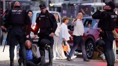 Police officers restrain a person who was participating in a demonstration called by Spanish neonazi group Nucleo Nacional in Madrid, on October 3, 2026. (AFP)