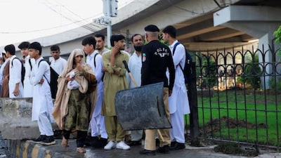 A police officer stops people to access the area near Red Zone, a day after Pakistan imposed a state of emergency in Khyber Pakhtunkhwa province. (Reuters)