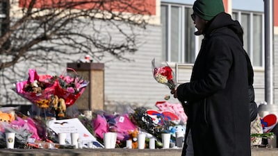 A man visits a makeshift memorial on the steps of the town hall, days after the shooting in Tumbler Ridge, British Columbia, Canada. On February 10, suspected shooter, Jesse Van Rootselaar killed her mother and half-brother at their home before going to Tumbler Ridge Secondary School, where she killed six people and injured 27 others before killing herself. File image/Reuters