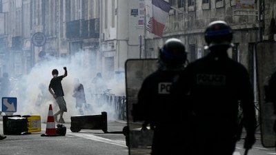 Police officers stand after firing tear gas canister to disperse remaining protesters at the end of a demonstration part of a nationwide day of actions called by high-school students, joined by unions and teachers, who for days have been demanding better learning conditions in protests punctuated by violent confrontations in Bordeaux, southwestern France. AFP