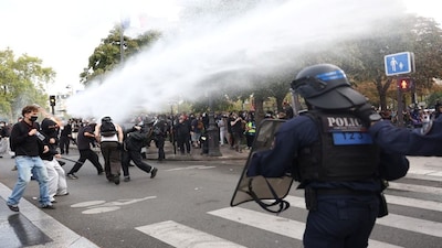 Protesters react as French police use water canon amid clashes at the Place de la Nation during a demonstration by high school and university students, supported by teachers' union and school parents, in Paris as part of a nationwide day of protests and blockades. Reuters