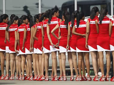 Formula One grid girls wait to enter the pit lane after the third practice session. Reuters