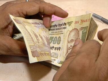 Cashier counts currency notes inside bank in Lucknow