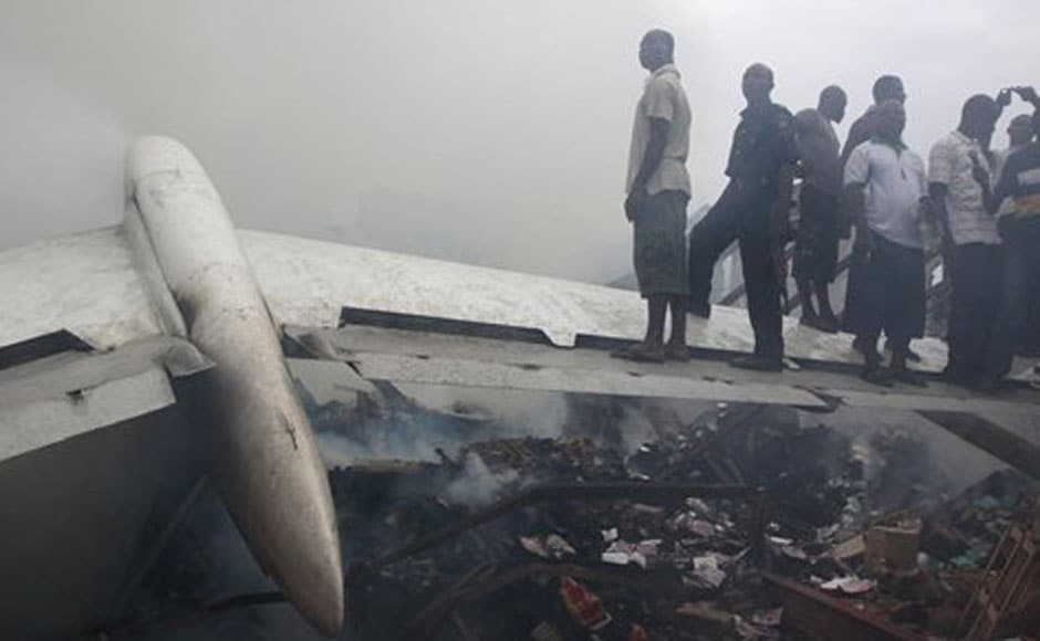 People stand on a wing of the wrecked passenger plane in Lagos, Nigeria. AP People stand on a wing of the wrecked passenger plane in Lagos, Nigeria. AP