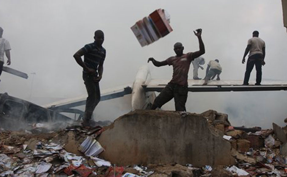 Onlookers throw debris away from the tail wing of the crashed passenger plane. AP Onlookers throw debris away from the tail wing of the crashed passenger plane. AP