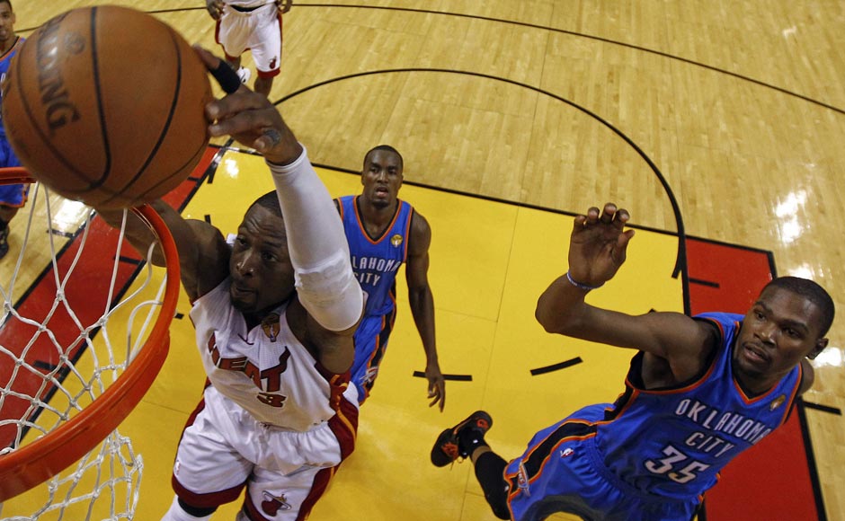 Miami Heat shooting guard Dwyane Wade (3) gets past Oklahoma City Thunder small forward Kevin Durant (35) and power forward Serge Ibaka (9) from Republic of Congo to dunk the ball during the second half at Game 3 of the NBA finals basketball series. AP Miami Heat shooting guard Dwyane Wade (3) gets past Oklahoma City Thunder small forward Kevin Durant (35) and power forward Serge Ibaka (9) from Republic of Congo to dunk the ball during the second half at Game 3 of the NBA finals basketball series. AP