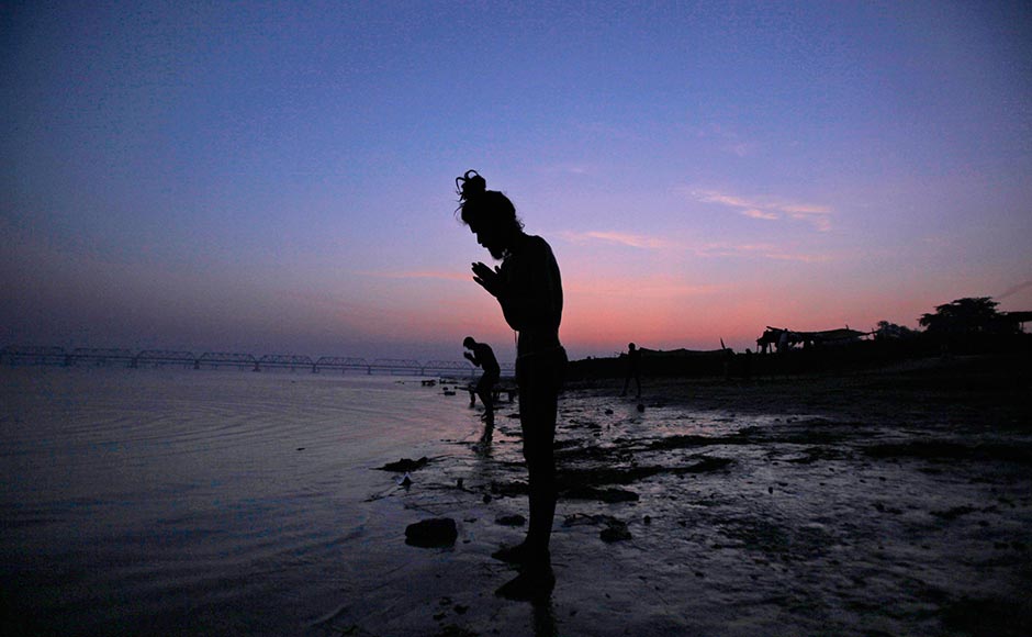 A Hindu holy man offers prayers by the Saryu River on the eve of the anniversary of the Babri mosque demolition in Ayodhya. Rajesh Kumar Singh/AP A Hindu holy man offers prayers by the Saryu River on the eve of the anniversary of the Babri mosque demolition in Ayodhya. Rajesh Kumar Singh/AP
