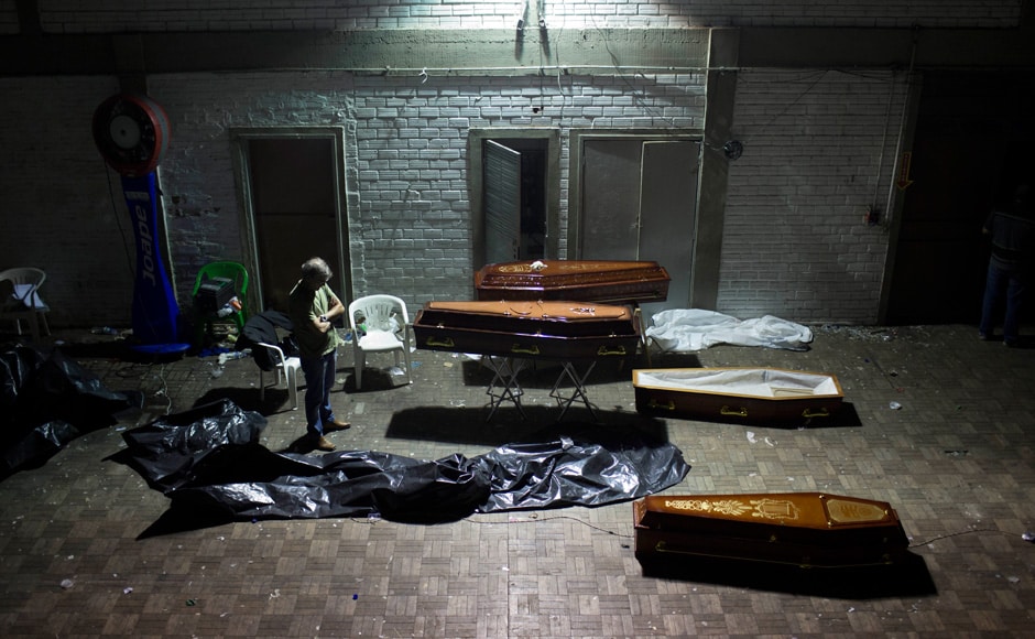 A man stands around coffins containing the remains of victims after the bodies were identified at a gymnasium in Santa Maria city, Rio Grande do Sul state, Brazil, Sunday, Jan 27, 2013.AP