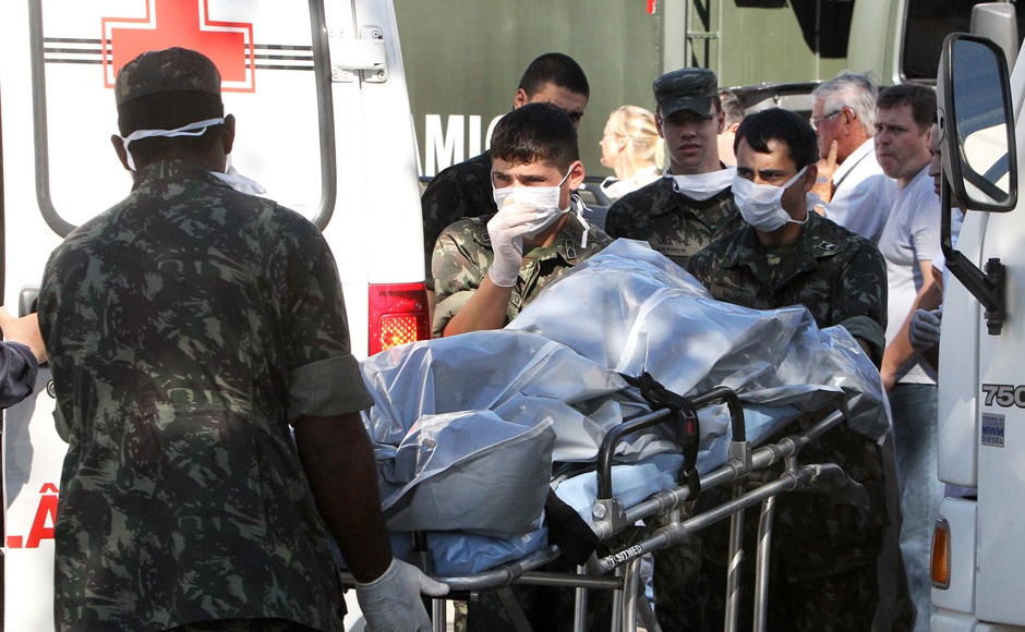 Brazil's soldiers carry the remains of a victim outside a gymnasium where bodies were brought for identification in Santa Maria city, Rio Grande do Sul state, Brazil, Sunday, Jan 27, 2013. AP
