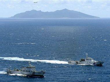 File photo of a Chinese surveillance ship (left) and a Japan Coast Guard vessel sail near the disputed islands. AP