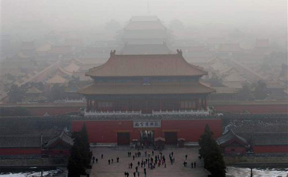 Visitors gather near an entrance to the Forbidden city amid the haze in Beijing : AP Visitors gather near an entrance to the Forbidden city amid the haze in Beijing : AP