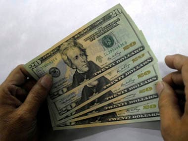 Employee shows dollar notes at foreign exchange unit at post office in Hyderabad