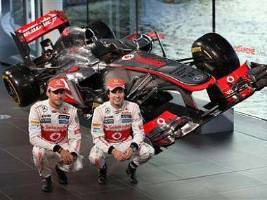 McLaren Formula One drivers Jenson Button and Sergio Perez pose at the unveiling of the McLaren MP4-28 at the company's headquarters in Woking. Reuters