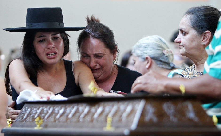 Relatives cry next to a coffin at a gymnasium where bodies were brought for identification in Santa Maria city, Rio Grande do Sul state, Brazil, Sunday, Jan 27, 2013. AP