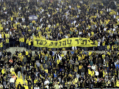 Supporters of Beitar Jerusalem soccer club hold a banner reading "Beitar will always remain pure". Reuters