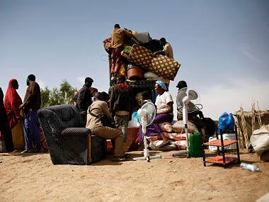 Malians fload a pickup truck with goods and furniture as they arrive after crossing the Niger river at Korioume Port, south of Timbuktu. AP