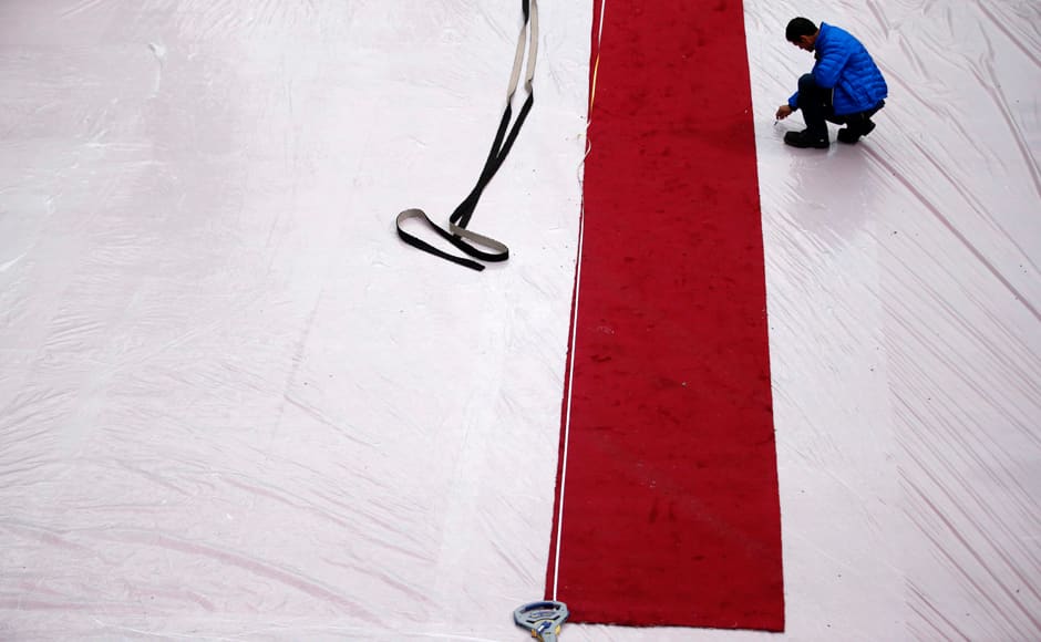 A worker writes on a plastic cover in the red carpet arrival area outside the Dolby Theatre in the Hollywood section of Los Angeles, Thursday, Feb. 21, 2013. AP