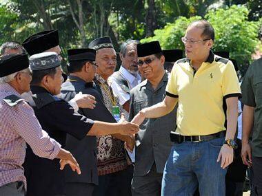 Philippine President Benigno Aquino III, right, is greeted by Moro Islamic Liberation Front (MILF) rebels during his visit to Camp Darapanan. AP
