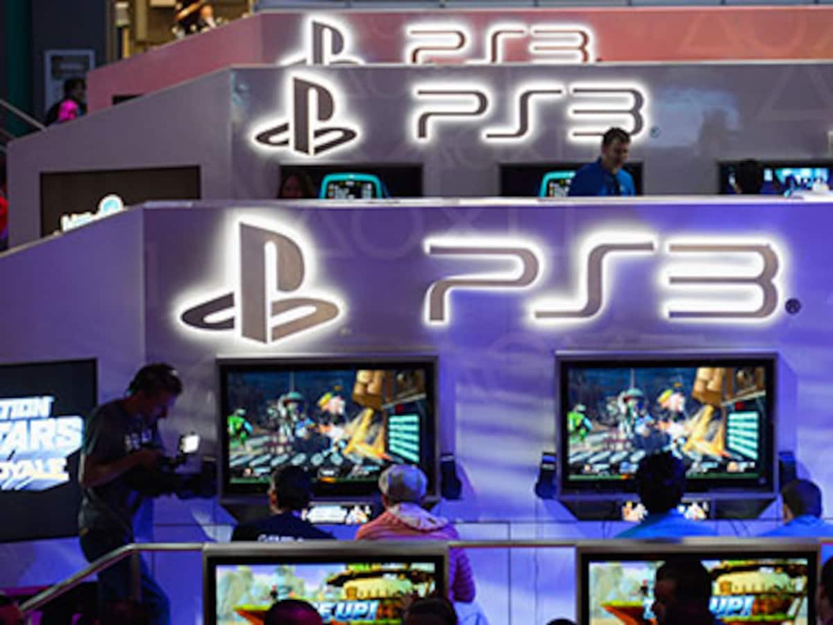 Visitors are reflected in a PlayStation 4 sign outside the Sony