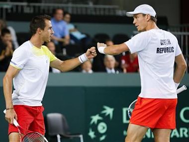 Tomas Berdych (R) of the Czech Republic bumps fists with his team mate Lukas Rosol during his Davis Cup world group round 1 tennis doubles match against Stanislas Wawrinka and Marco Chiudinelli of Switzerland, Reuters