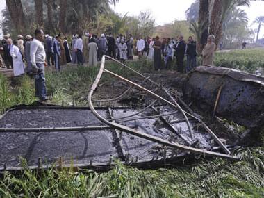 Egyptians gather at the site of a balloon crash where the remains of the burned gondola are seen. AP