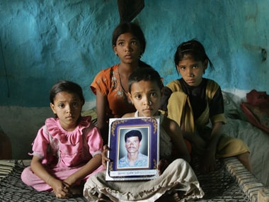 Four daughtersof the late 35-year-old Indian cotton farmer Neelkhant Haste mourn his death with a picture of him, after Haste committed suicide by consuming pesticide. Desperate and debt-ridden with loan sharks demanding up to 120 percent annual interest, the failed harvests and tumbling prices have driven businesses to the wall and farmers to suicide. AFP