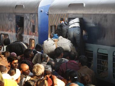 A pilgrim from Kumbh tries to board a train at the Allahabad station. AP.
