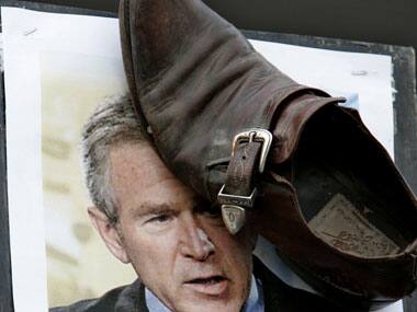 A protester displays a shoe stuck to a picture of then US President George W Bush during a protest in Amman in 2008. Reuters