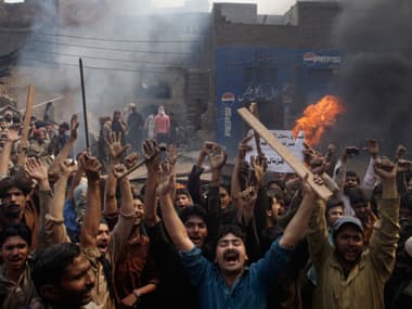 An angry mob reacts after burning Christian houses in Lahore. AP
