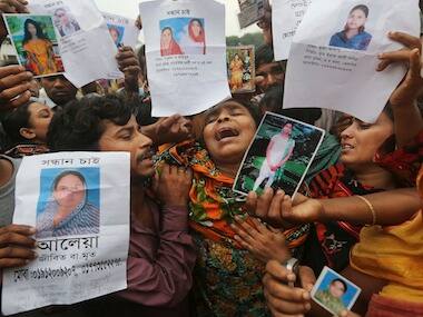 In this April 27, 2013 file photo, Bangladeshi relatives of garment worker Mohammed Abdullah cry as they pass others looking for missing relatives AP