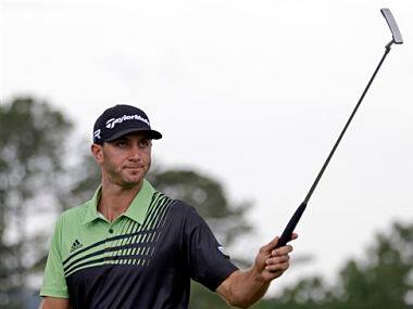 Dustin Johnson raises his putter on the 18th hole after the first round of the Masters golf tournament. AP