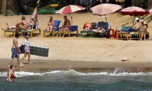 Tourists relax at the Anjuna beach in Goa