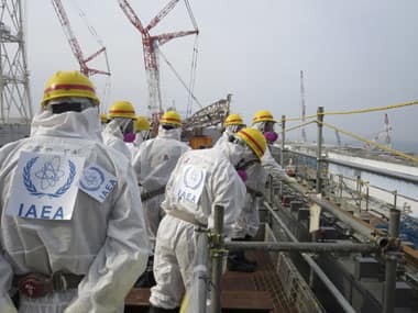 In this photo released by TEPCO, an IAEA team wearing protective gear inspects the fuel storage pool of the No. 4 reactor building at Fukushima Daiichi nuclear power plant in Okuma town, Fukushima. AP