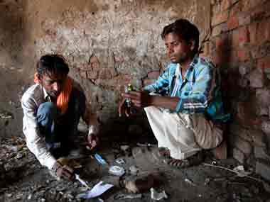 Pargat Singh (left) a long time drug user, and his friend prepare to inject drugs in an abandoned building in Punjab. NYT