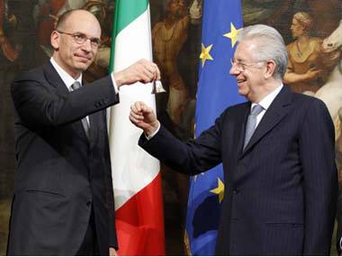 Newly appointed Prime Minister Enrico Letta (L) rings the silver bell to signify the start of his first cabinet meeting at Chigi palace in Rome on Sunday. Reuters
