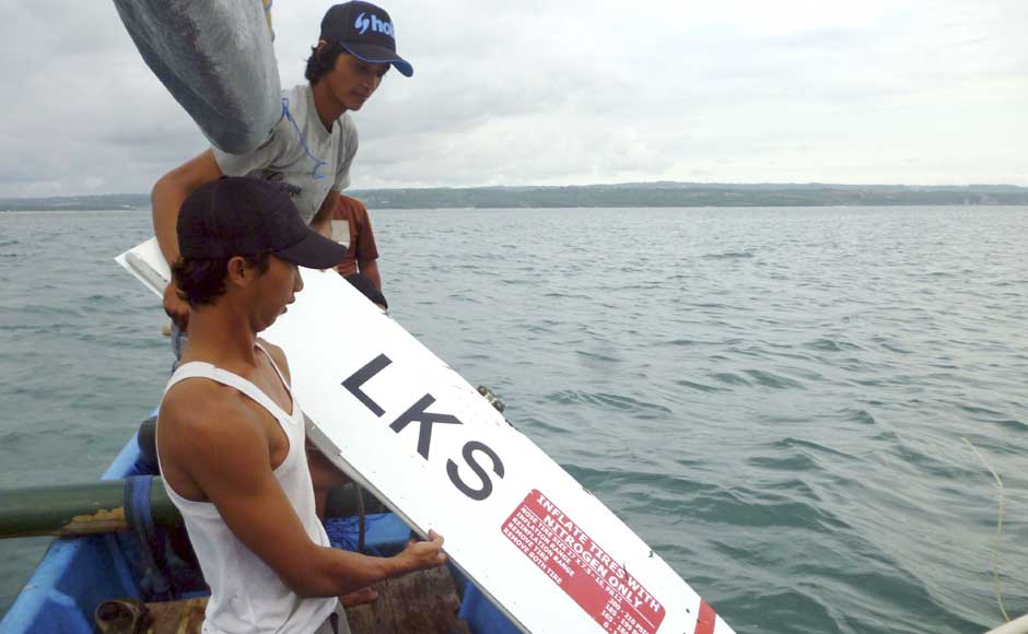 Indonesian fishermen hold a part of the wreckage of a Lion Air plane in Bali, Indonesia on 13 April 2013. AP Indonesian fishermen hold a part of the wreckage of a Lion Air plane in Bali, Indonesia on 13 April 2013. AP