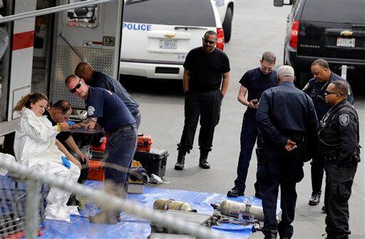 Firefighter, left, gets dressed in a protective suit before going into a government mail screening facility. AP