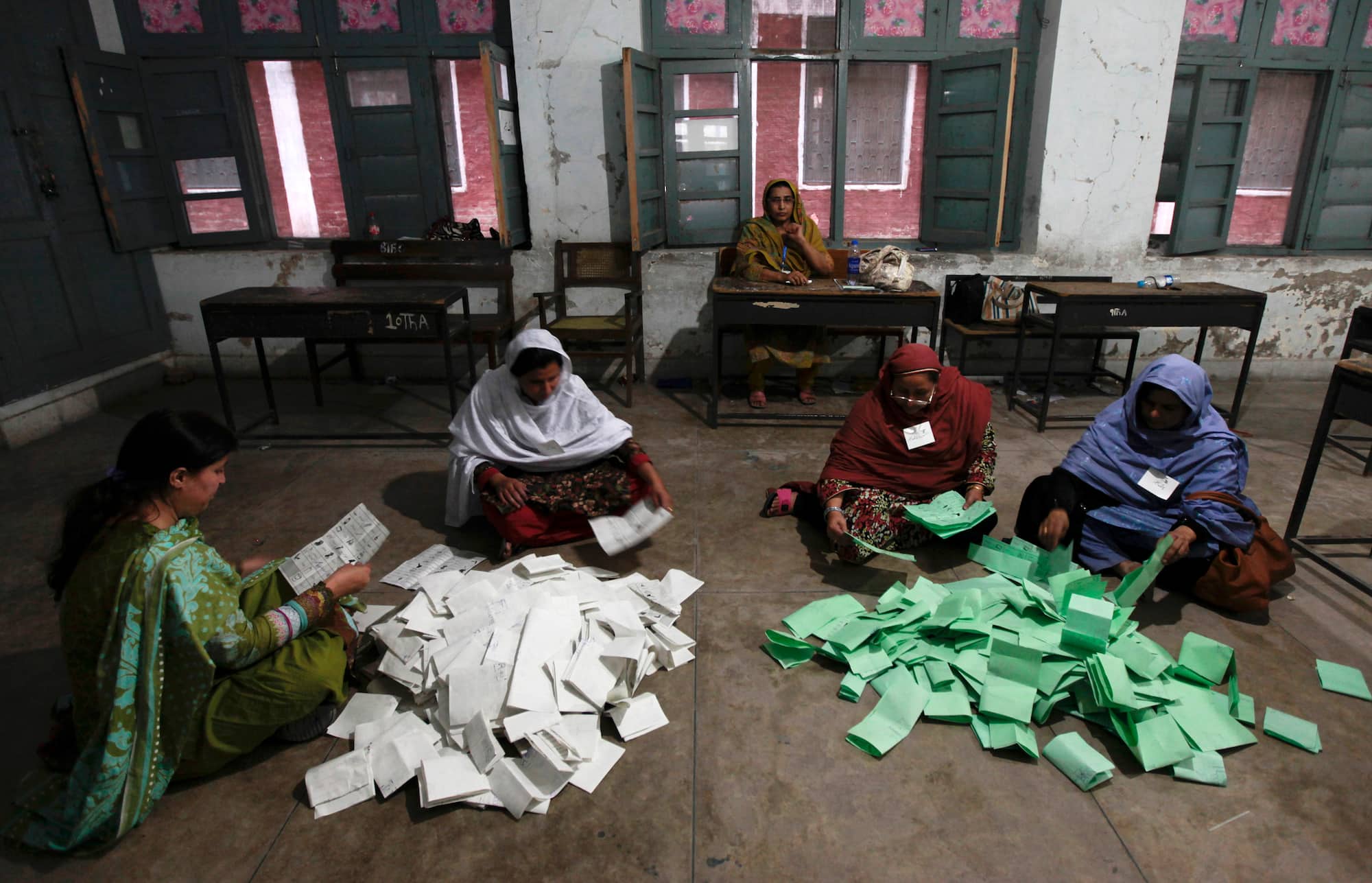 Election workers count ballots after polls closed for Pakistan's general elections in Peshawar