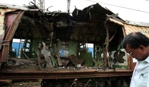 Forensic officer examines damaged railway train compartment hit by Tuesday’s bomb blast in Mumbai