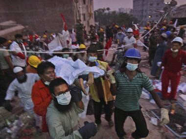 Rescue workers carry out corpses. AP.