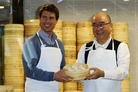 Tom Cruise (L) poses with Din Tai Fung President Yang Chi-hua and xiaolongbao, or dumpling, that they have made, at the restaurant’s Taipei 101 branch. Reuters