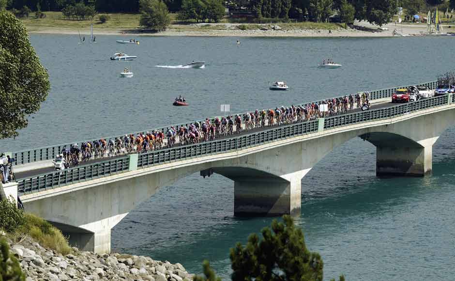 The peloton crosses the Lac de Serre-Poncon during stage nine of the Tour de France from Bourg d’Oisans to Gap on July 14, 2003. Getty Images