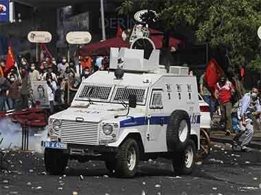 A Turkish protester, right, throws a stone at police vehicle as the protesters clash with security forces in Ankara, Turkey, Saturday, June 1. AP