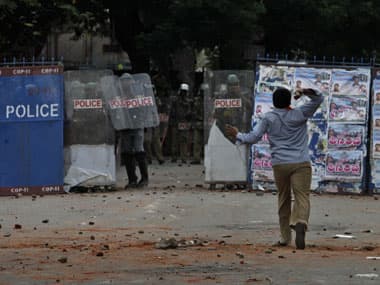 A student hurls stones at policemen in Hyderabad. AP